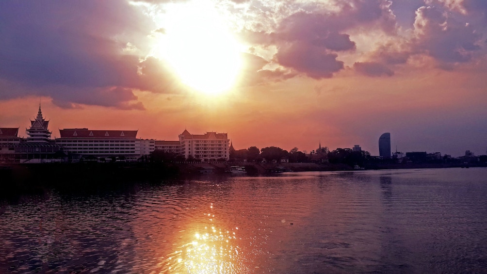 the sun setting near the water in Cambodia