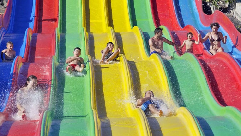 group sliding down a wavy water slide at the waterpark in West Africa