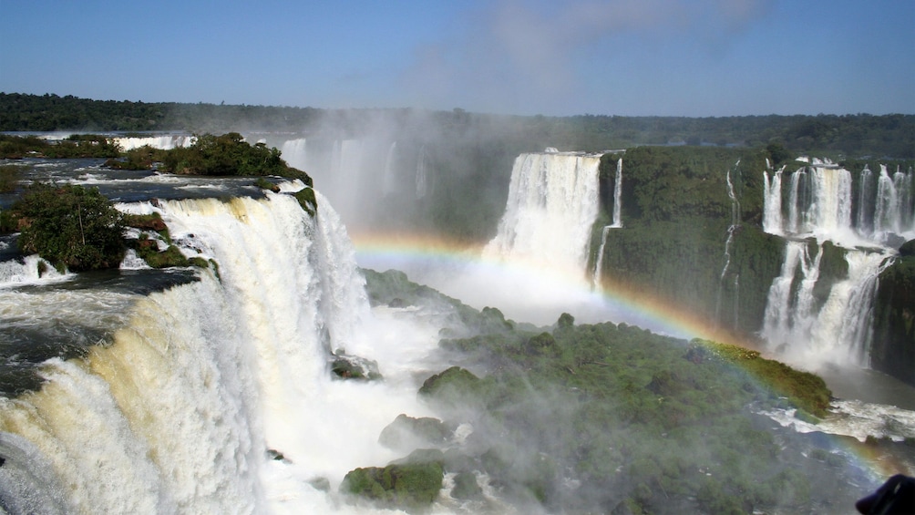 rainbow forming over the waterfalls in Brazil