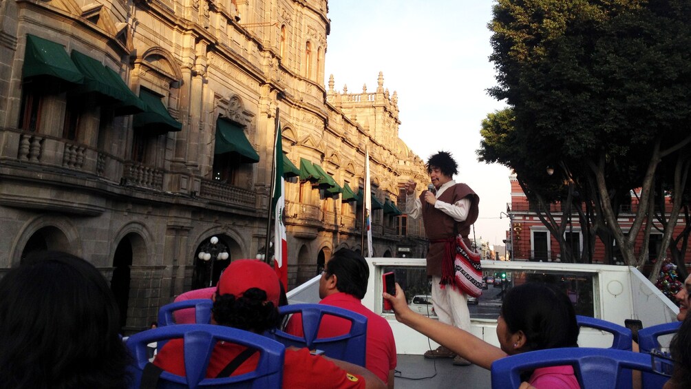 Tour guide talking to tourists on bus in Puebla