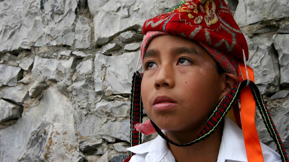 Young boy wearing traditional headdress in Cuetzalan