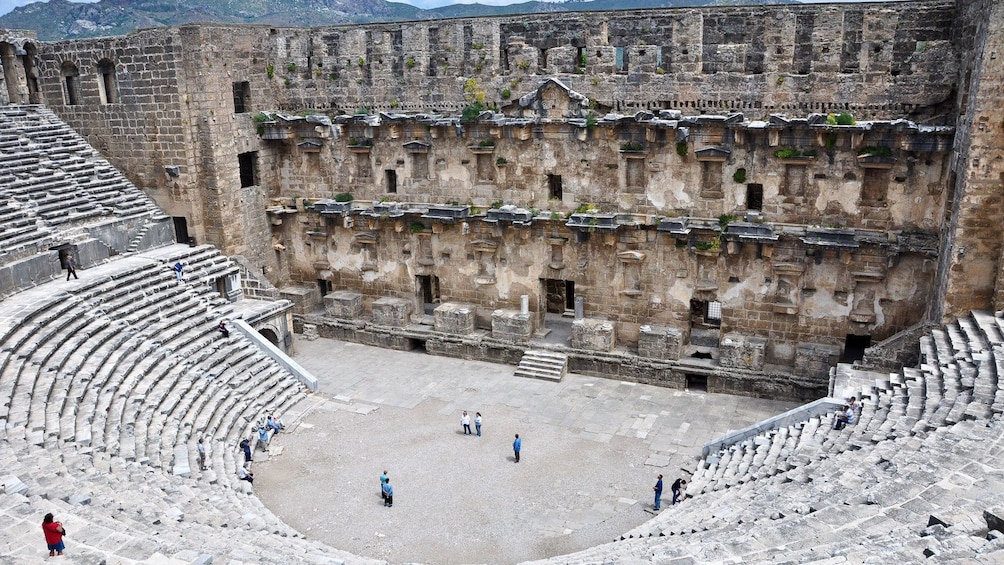 Show item 2 of 5. People stand in an amphitheater in Perge
