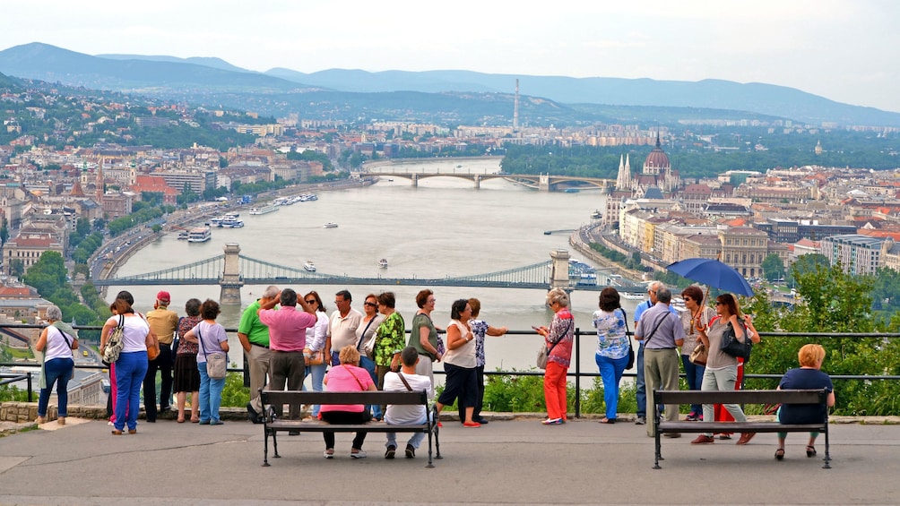 A group of people looking out at a river in budapest