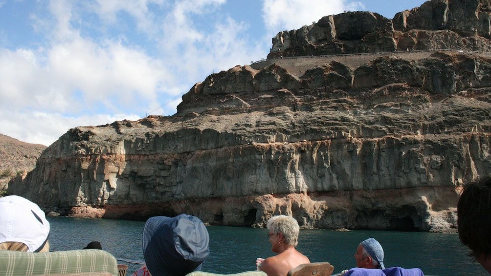 A Supercat Boat boat passing cliffs along the shore of Gran Canaria