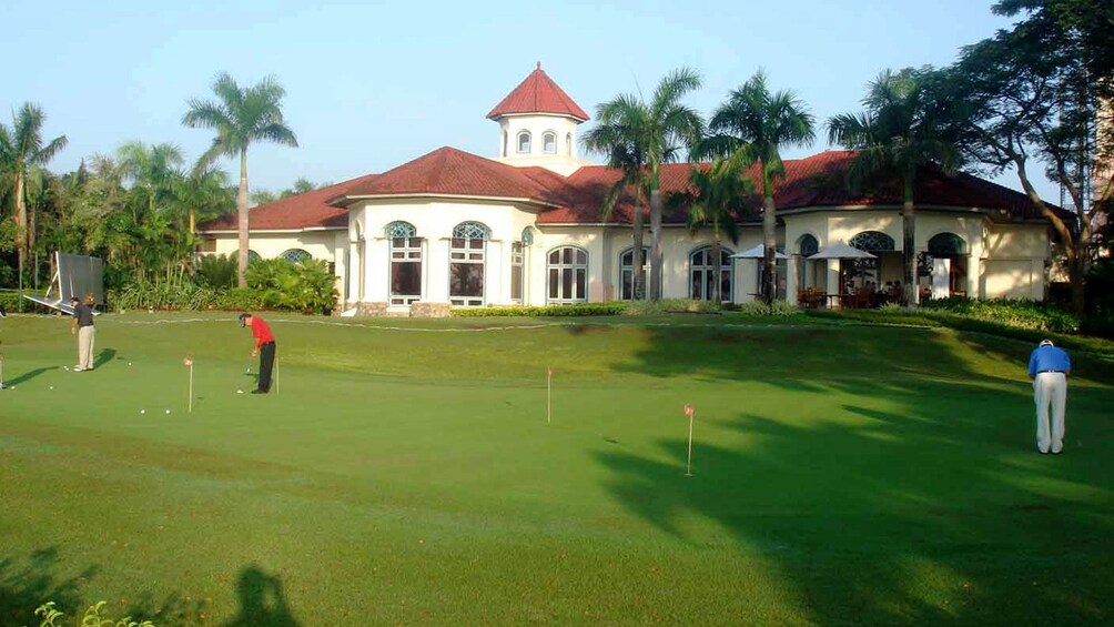 Pun Hlaing Golf Club with golfers on the green in front of the clubhouse in Myanmar