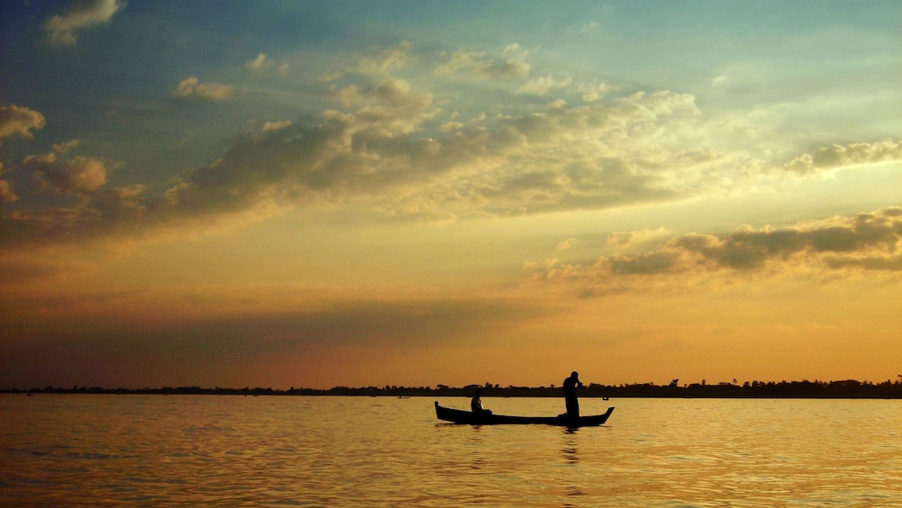 Silhouette of a boating couple on the Yangon River at sunset in Myanmar