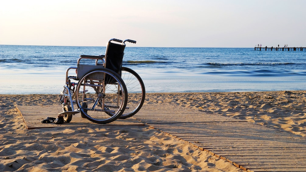 Wheelchair parked on a boarded path on the beach