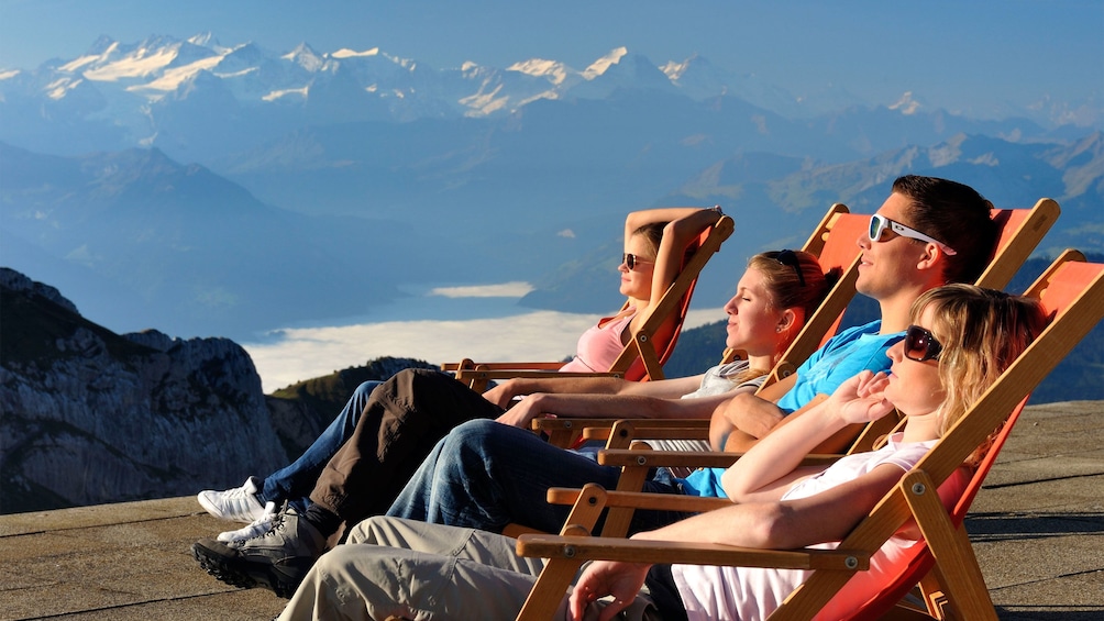 Group relaxing in lounge chairs in the sun on Mount Pilatus in Lucerne