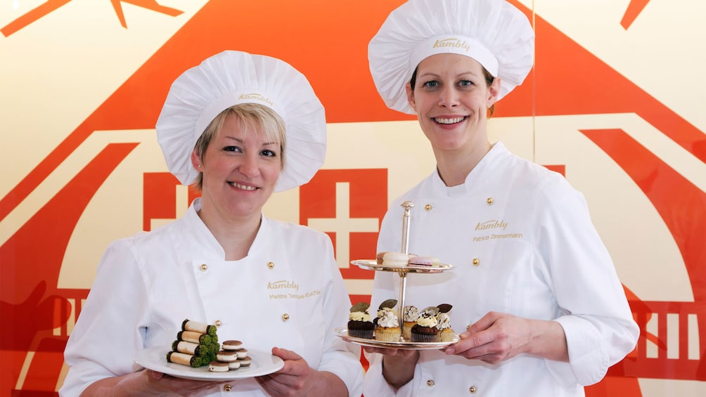 Pair of chefs with plates of desserts in Bern
