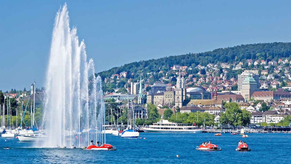 Tourists driving recreational boats on the water near the harbor in Zurich