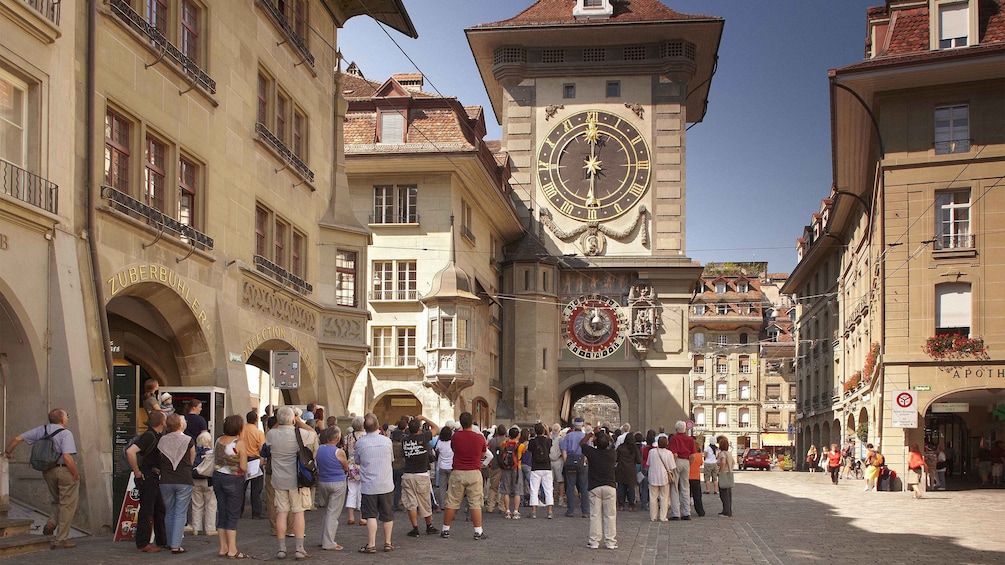 Tour group looking up at the large Zytglogge clock tower in Bern