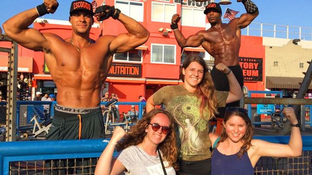Women posing with Bodybuilders in Muscle Beach