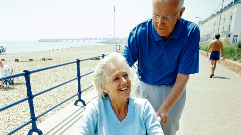 Husband assisting his wife in a wheelchair