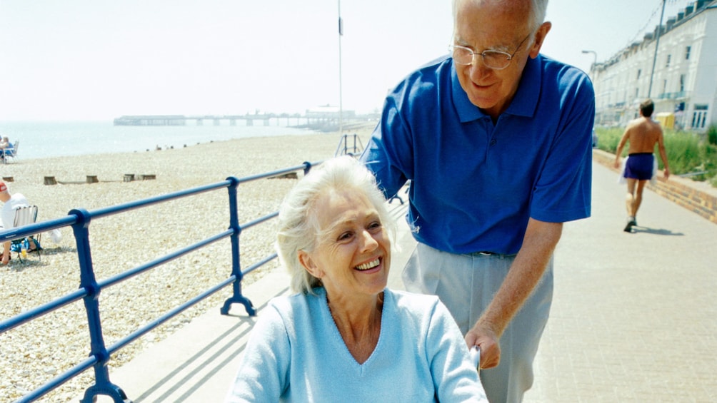 Elderly man assisting his wife in a wheelchair