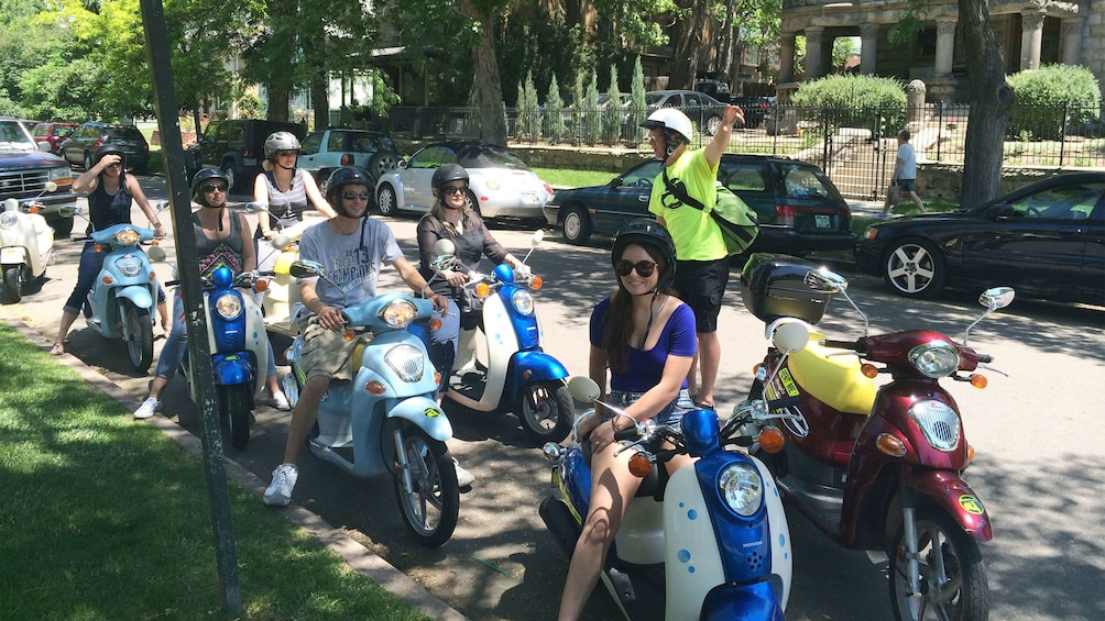 Tourists prepare to embark on a tour via scooter