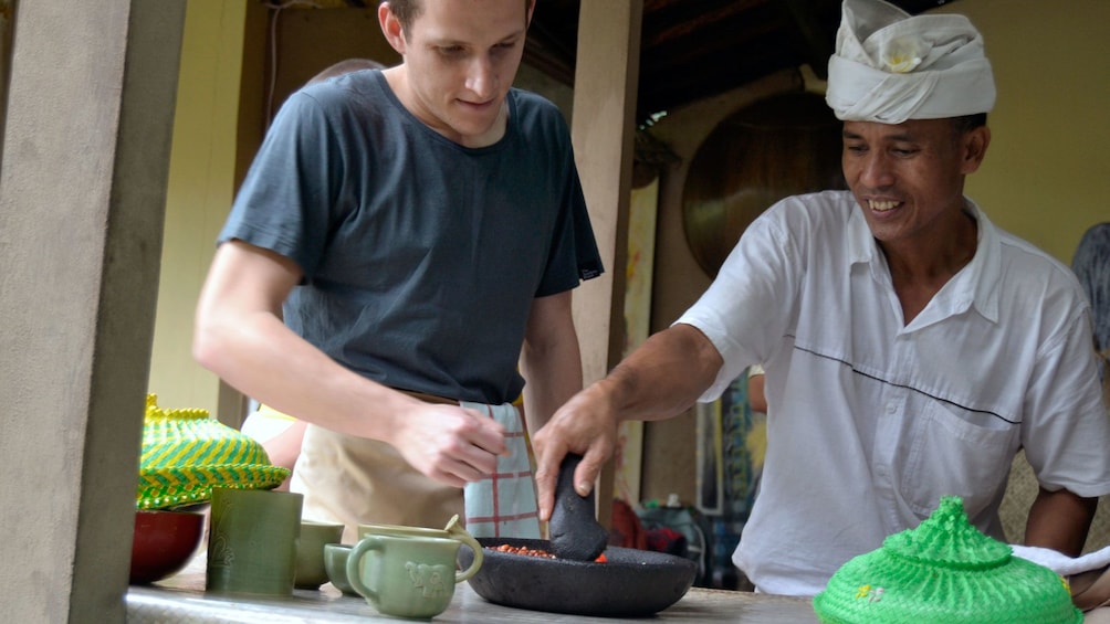 Chef teaching a man to cook Balinese food in Bali