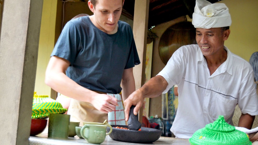 Chef teaching a man to cook Balinese food in Bali