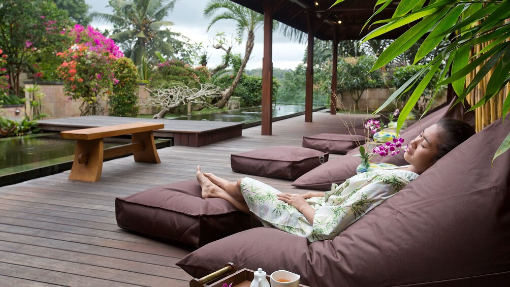 Tampilkan item 5 dari 6. Woman relaxing on a deck at a spa in Bali