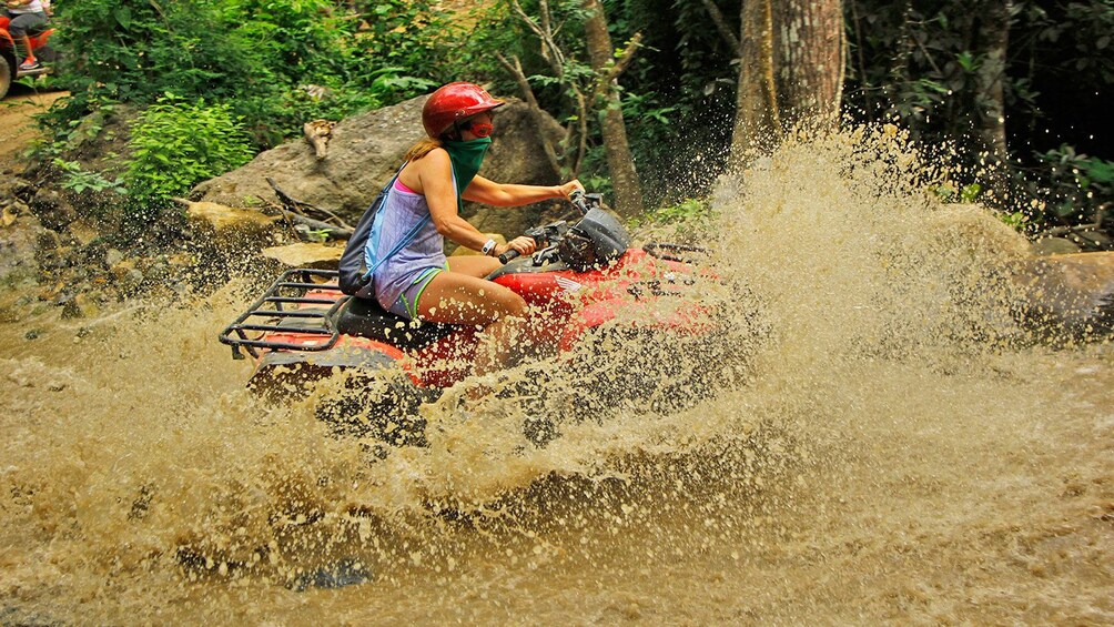 Woman on an ATV splashing through the river in Puerto Vallarta