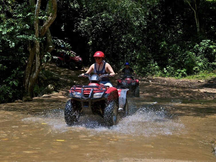 ATV riding through water on the road 