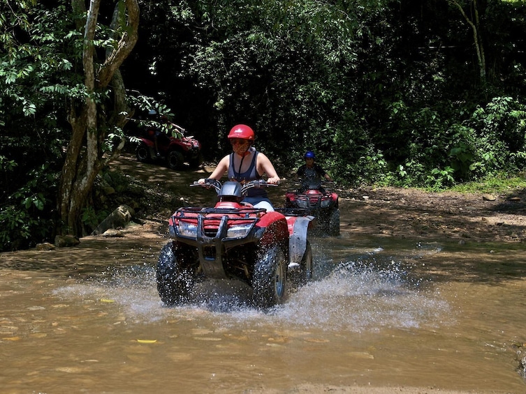 ATV riding through water on the road 