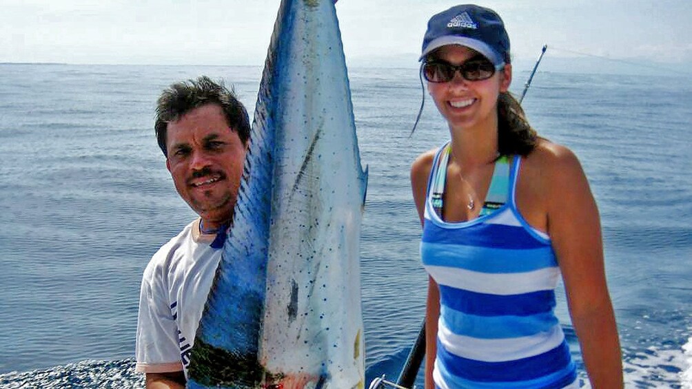 Fishing guide and woman with a sailfish on a boat
