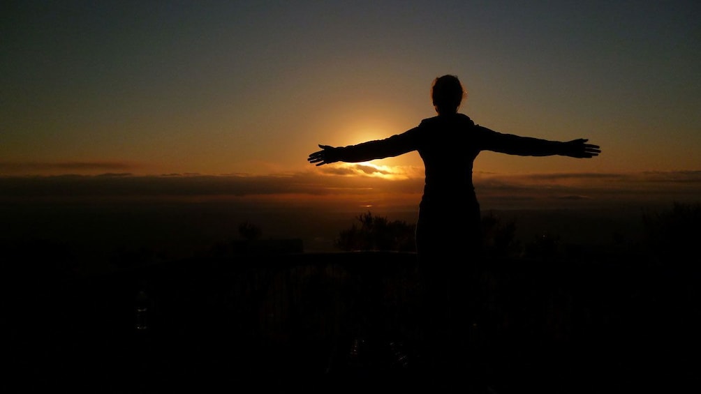 Show item 1 of 5. hiker enjoying the warmth of the rising sun on the mountain in Australia