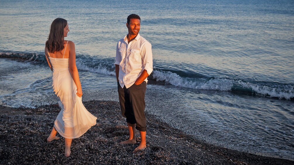 Charger l’élément 4 sur 5. Couple standing in the ocean in santorini