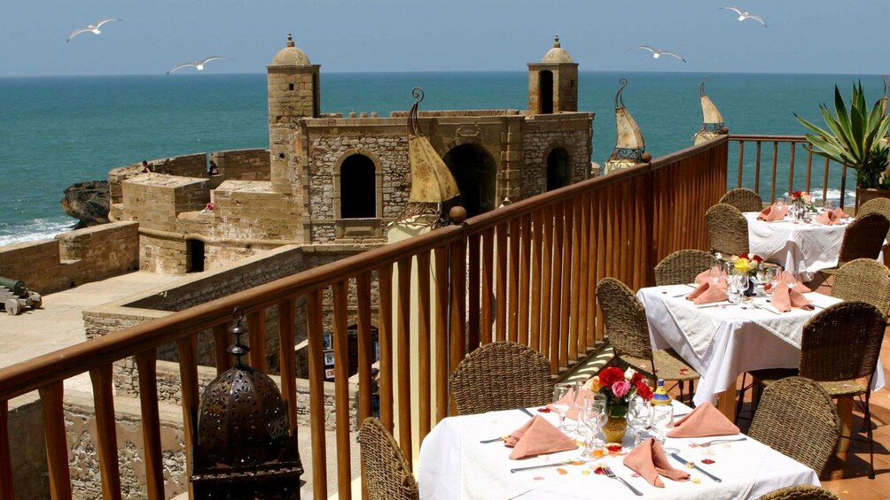 Outside dining on a terrace overlooking the ancient city walls and coastline in Essaouira