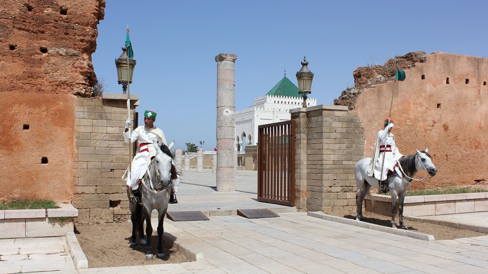 knights on horseback flanking gated entrance