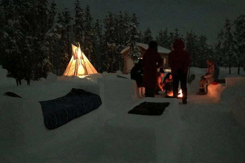 Guests huddled around the fire by the snow seating.