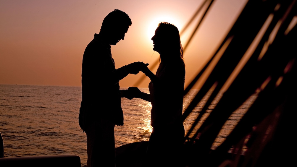 Couple dancing in the sunset aboard the Couple enjoying the Twilight Sunset Catamaran Cruise in the Turks & Caicos Islands