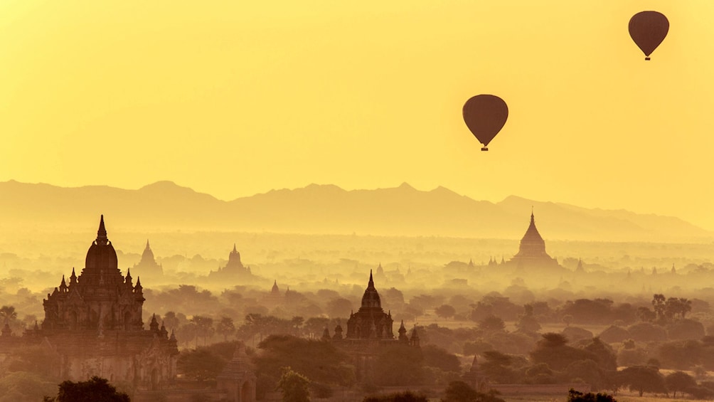 Foggy view of two hot air balloons floating over Bagan 