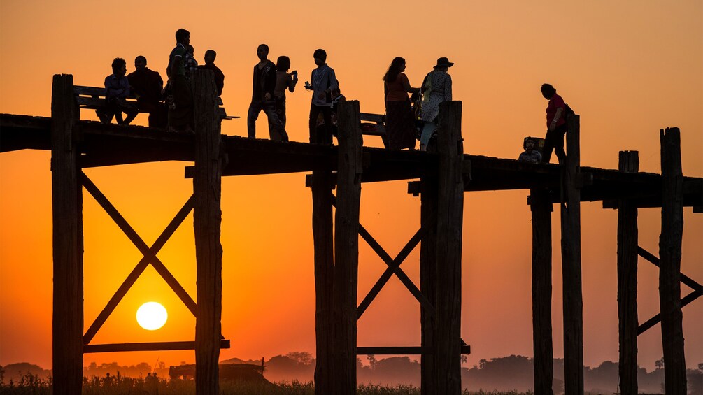 People on the U Bein Bridge at sunset in Mandalay 