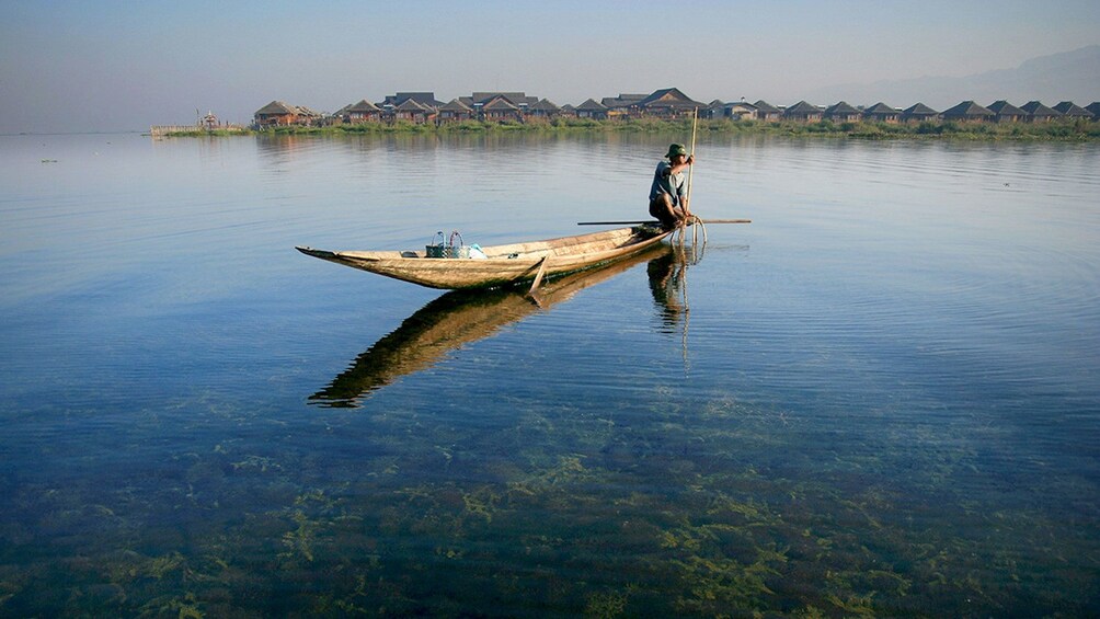 Local man on a wooden boat in Inle Lake 