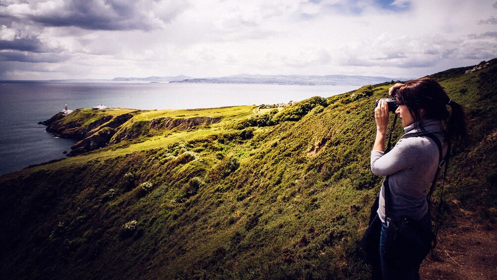 Woman taking a photo with her camera while on a photography tour of Dublin's highlights 