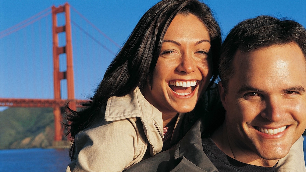 Couple smiling in front of the Golden Gate Bridge in San Francisco 
