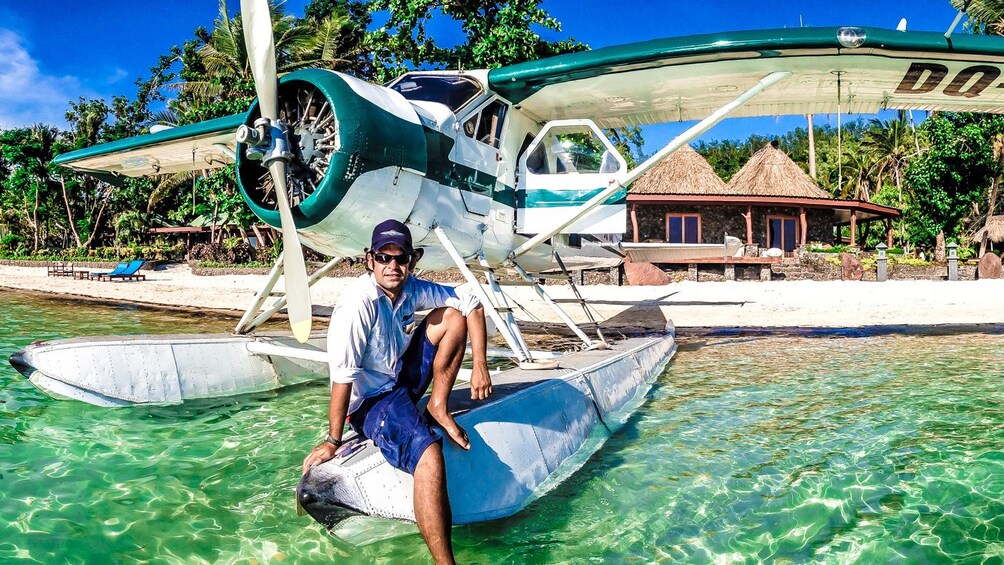 Show item 4 of 5. man sitting on float of plane in fiji