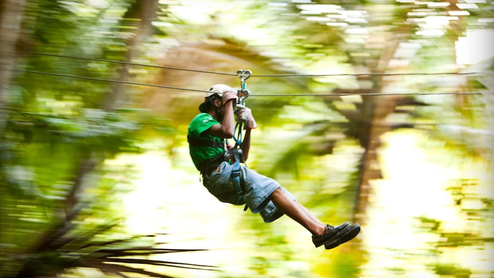 man ziplining through the rainforest in Antigua