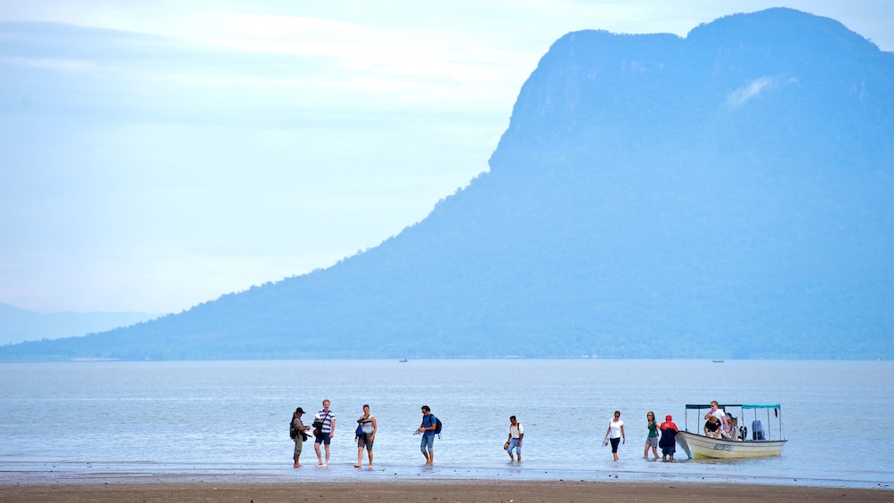 group walking to shore from a small boat ride in Malaysia