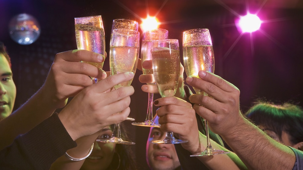 People raising their champagne glasses at a Las Vegas Club Crawl 