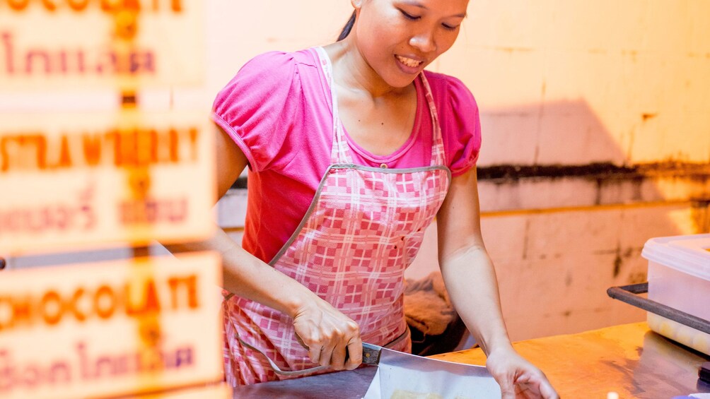 正在顯示第 3 張相片,共 5 張。 woman preparing food at the market in Thailand