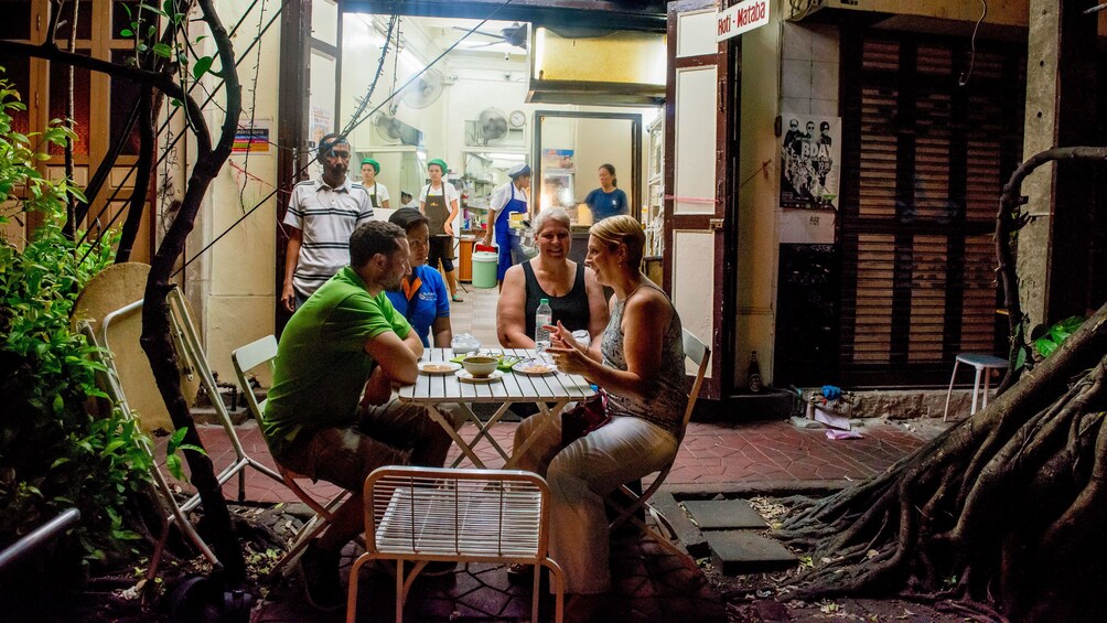 正在顯示第 4 張相片,共 5 張。 group enjoying street food at a small table outside in Thailand