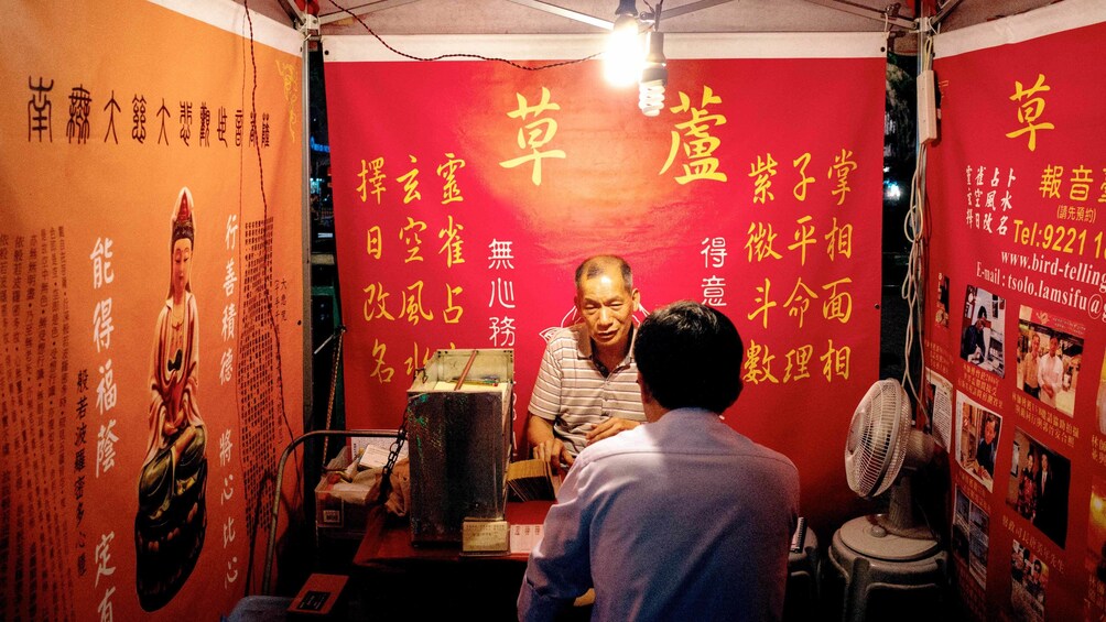 Man stepping into a small business in Kowloon Hong Kong at night 