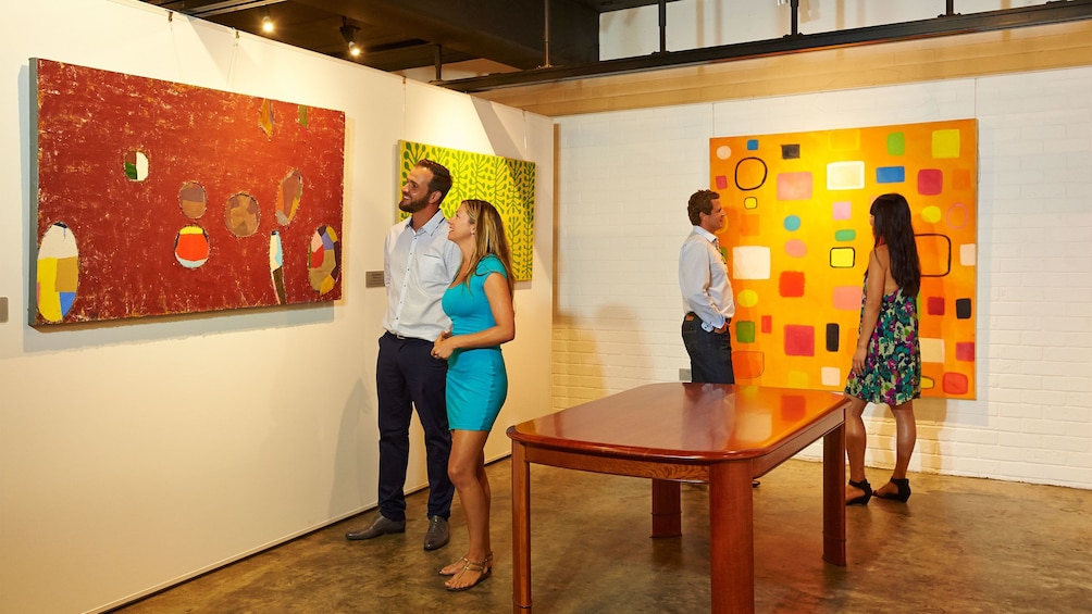 Two couples viewing featured art in gallery.