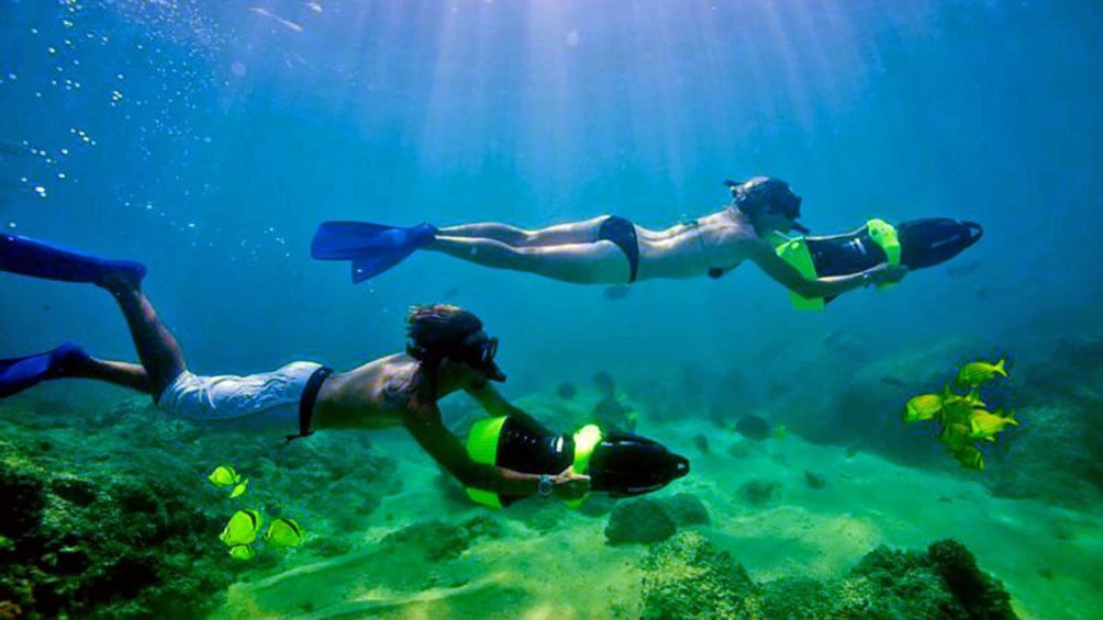 Couple swimming along the ocean floor with water propellers in Los Cabos