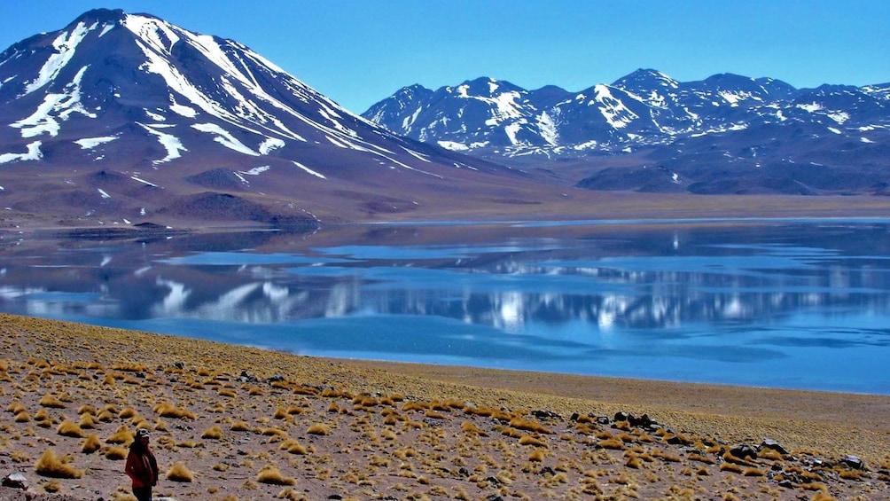 Calm lagoon at the base of snow-capped mountains in Chile