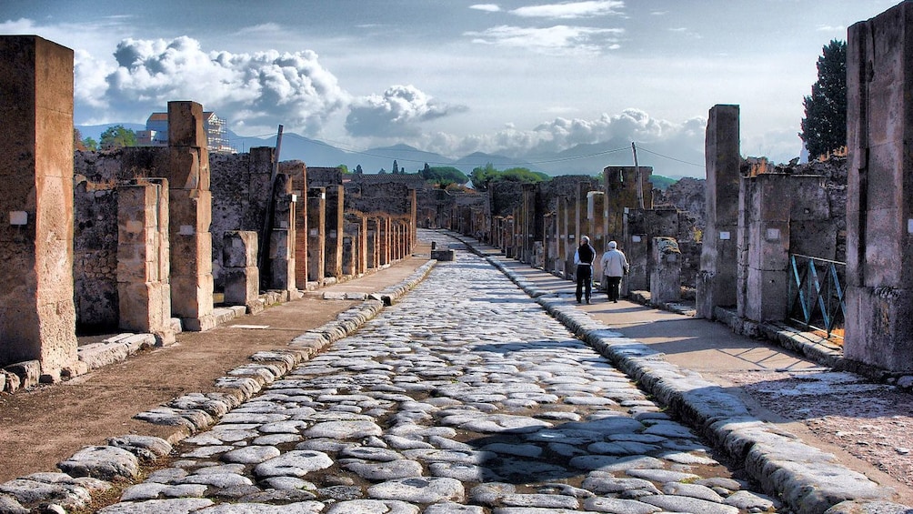 Ruins of pillars line a stone street in Pompeii