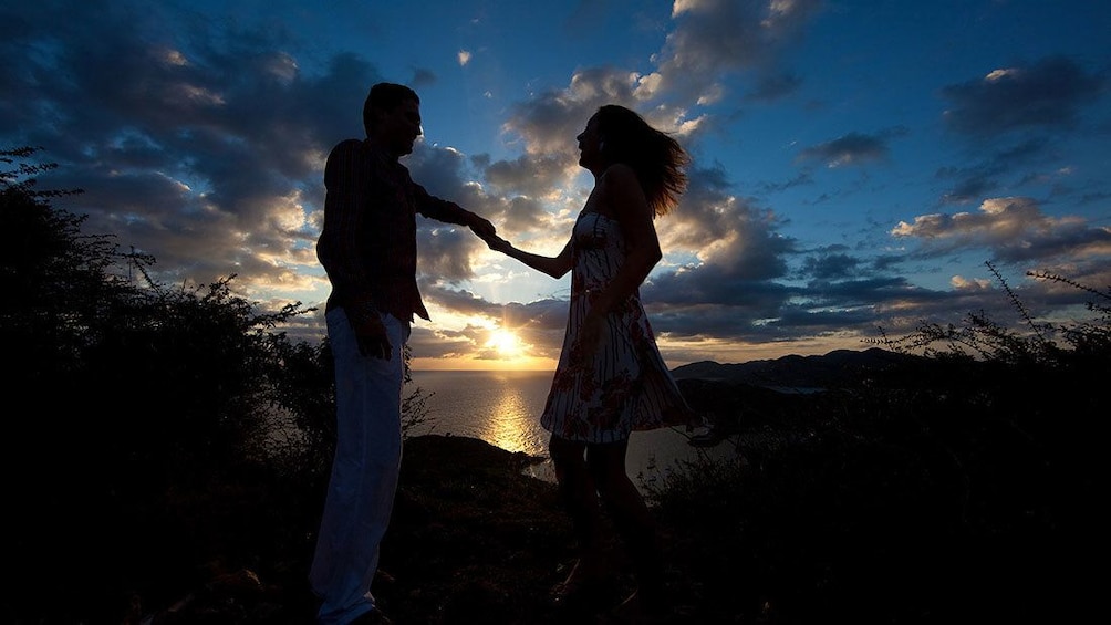 Show item 2 of 7. Two people on a beach at sunset in Antigua