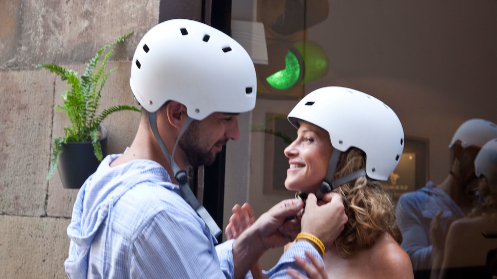 Couple fastening their helmets in preparation for the Ciutadella Park & Born District Segway Tour